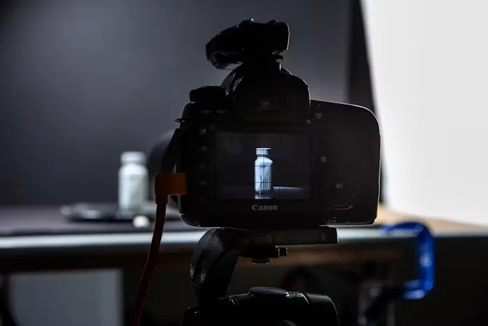 A camera filming a small product on a lit set