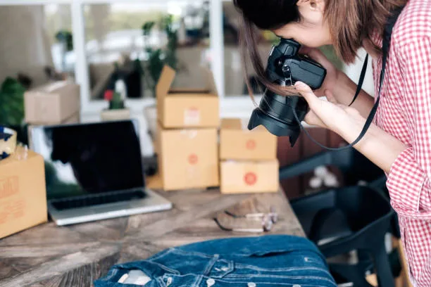 Someone shooting a denim flatlay with a camera