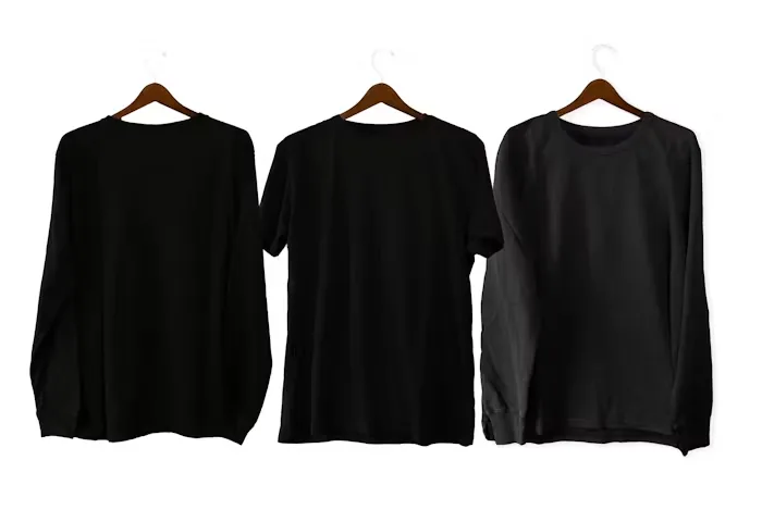 Three black shirts hanging side by side