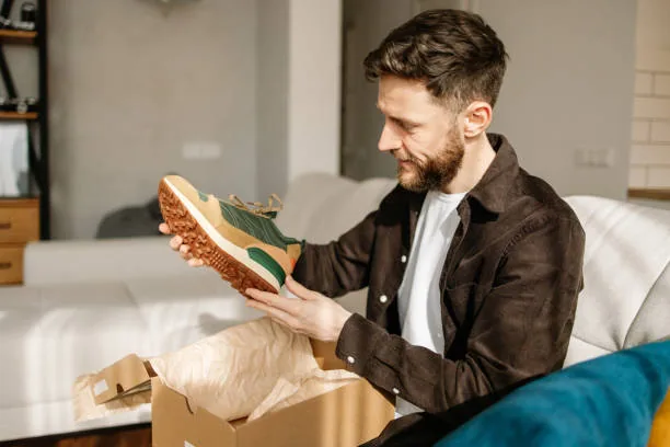 A customer unwrapping a shoe from a box at home